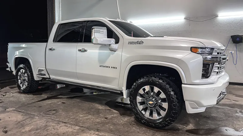 White lifted Chevrolet Silverado 2500 High Country after a full detail