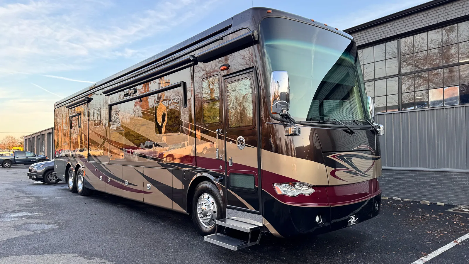 Polished maroon-and-gold Tiffin Class A luxury motorhome with a high-gloss finish after restoration
