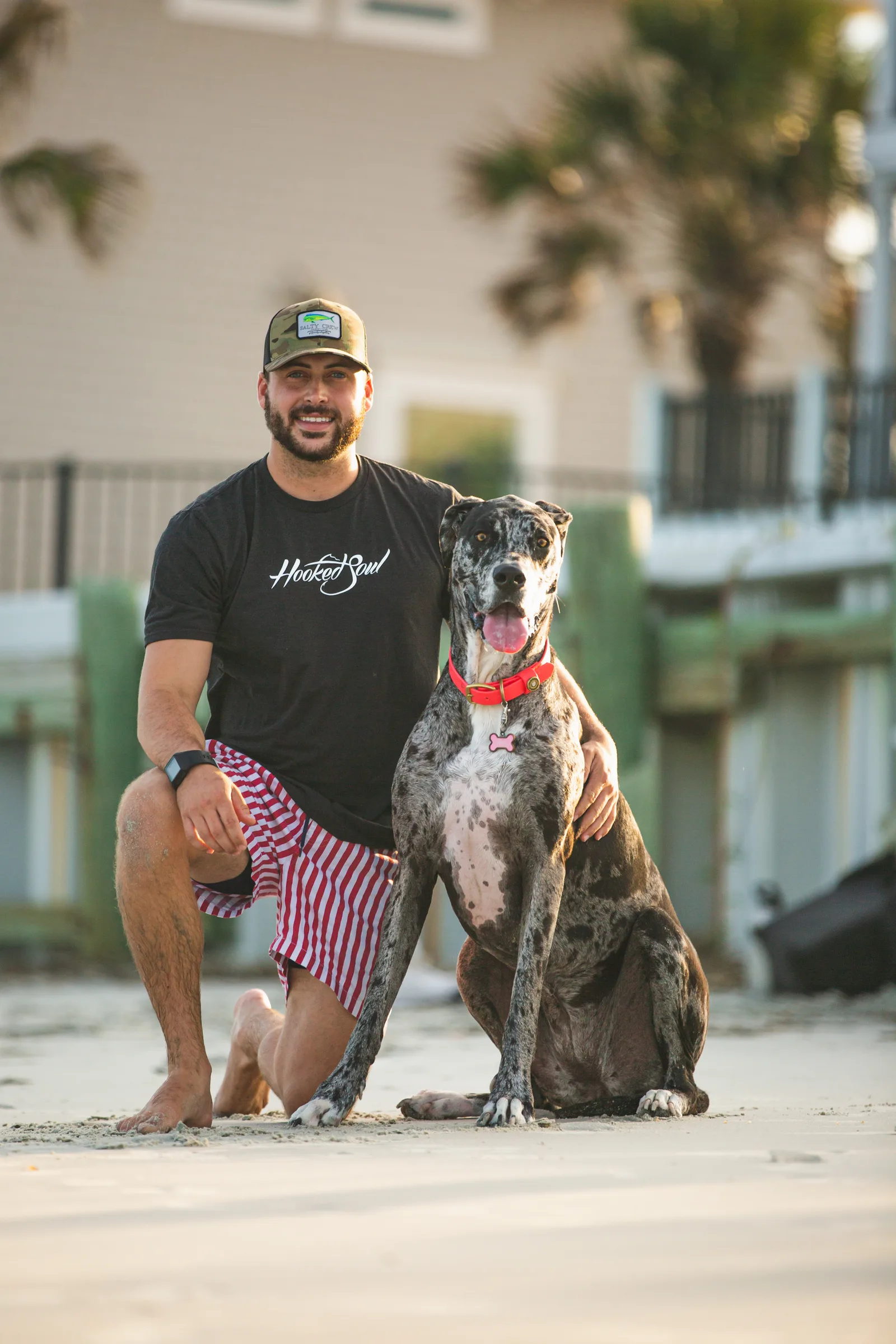 Trevor Haines, founder of Palmetto State Detail Co., on the beach at Pawleys Island with his Great Dane